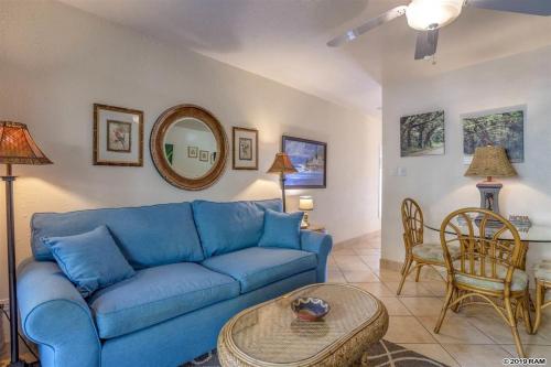 a living room with a blue couch and a table at Awesome Paki Maui Beach condos in Lahaina in Lahaina