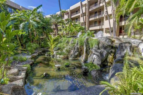 a garden with a waterfall in front of a building at Awesome Paki Maui Beach condos in Lahaina in Lahaina