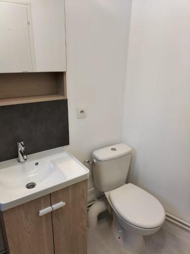 une salle de bain avec des toilettes blanches et un lavabo dans l'établissement Studio Sardinerie, à La Rochelle