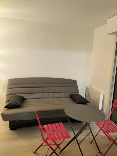 Cette chambre comprend un lit, deux chaises et une table. dans l'établissement Studio Sardinerie, à La Rochelle
