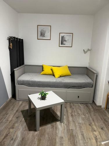 Cette chambre comprend un lit avec des oreillers jaunes et une table. dans l'établissement Verseau Flaine Forêt, à Arâches-la-Frasse