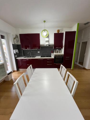 a kitchen with a long white table and chairs at Casa Conca D Oro in Rome