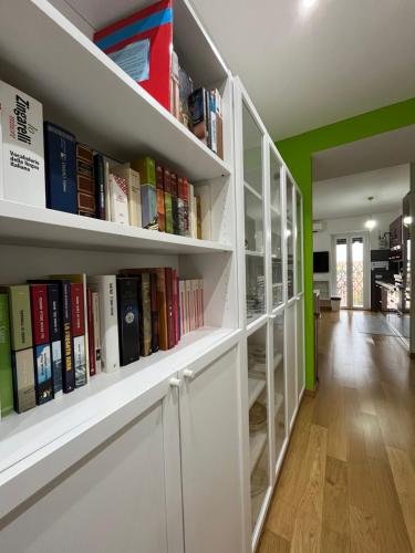 a library with white shelves filled with books at Casa Conca D Oro in Rome
