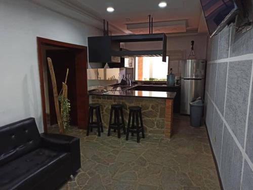a kitchen with a counter and stools in a room at Tu escapada en Chichiriviche Venezuela in Chichiriviche