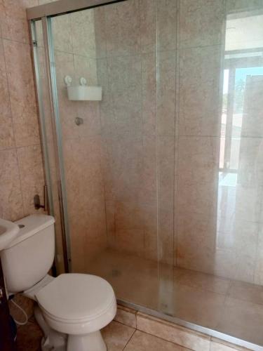 a bathroom with a toilet and a glass shower at Tu escapada en Chichiriviche Venezuela in Chichiriviche