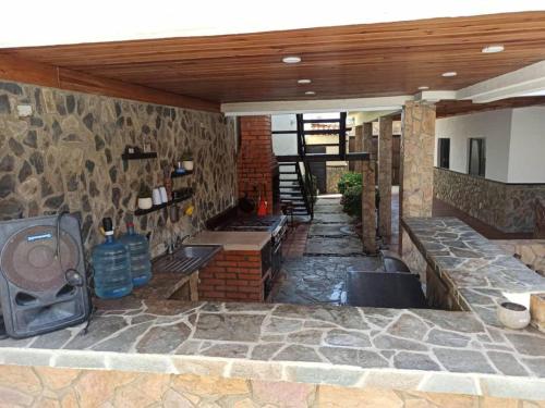a patio with a stone wall with a tv on it at Tu escapada en Chichiriviche Venezuela in Chichiriviche