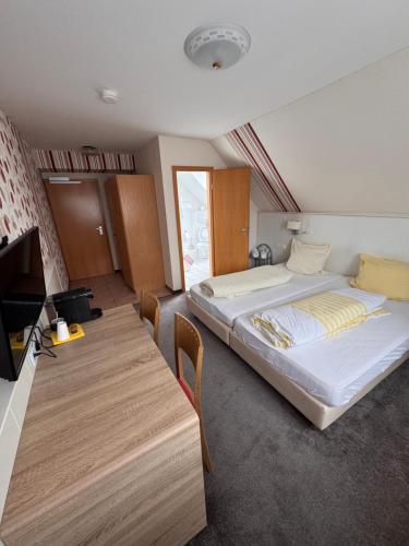 a hotel room with two beds and a table at Gasthof Hirschkeller in Göppingen