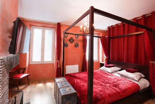 - une chambre avec un lit à baldaquin et des rideaux rouges dans l'établissement HARRY POTTER - GameRoom - La Quete du Sorcier - Experience Magique a Carcassonne, à Carcassonne