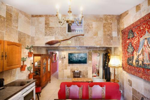 - une cuisine avec un canapé rouge dans une chambre dans l'établissement HARRY POTTER - GameRoom - La Quete du Sorcier - Experience Magique a Carcassonne, à Carcassonne