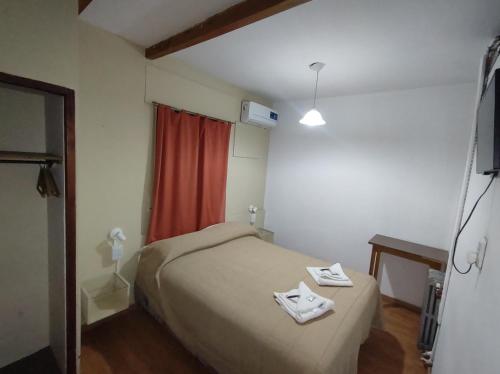 a small bedroom with a bed and a red curtain at Hotel Viñas San Rafael in San Rafael