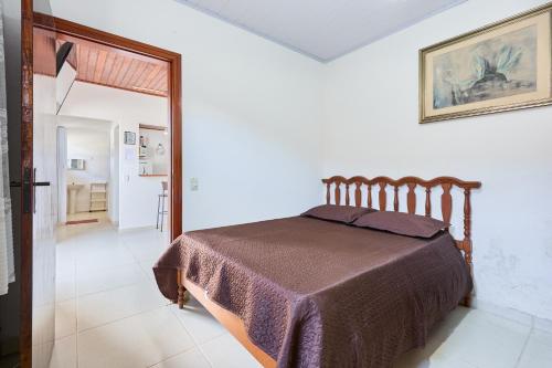 un dormitorio con una cama en una habitación en Casinha da Enseada, en Ubatuba