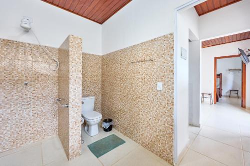 a bathroom with a toilet and a walk in shower at Casinha da Enseada in Ubatuba