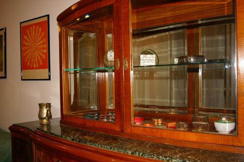 un armario de madera con puertas de cristal con platos. en Casa in Trastevere en Roma