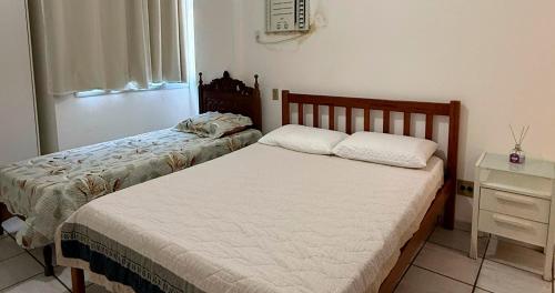 Ένα ή περισσότερα κρεβάτια σε δωμάτιο στο Apartamento Guarapari pé na areia com Wi-Fi e Garagem