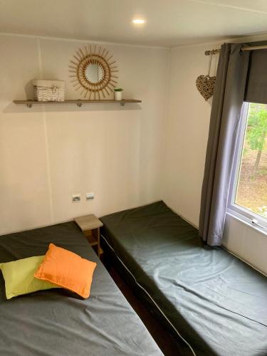 une petite chambre avec deux lits et une fenêtre dans l'établissement Mobil home Happiness33 dans camping 5 étoiles accès direct plage Vendays Montalivet, à Vendays-Montalivet