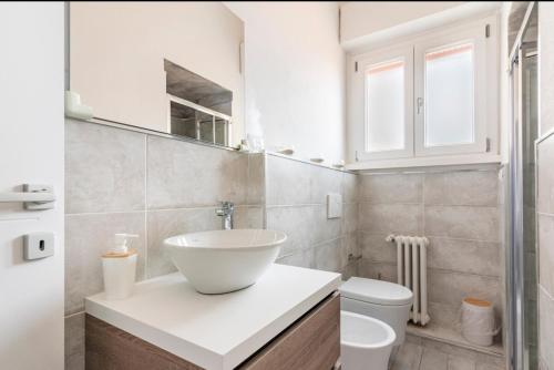 a white bathroom with a sink and a toilet at Casa centro vista mare in Sassari