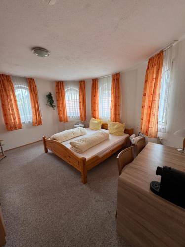 a bedroom with a bed and a table and windows at Gasthof Hirschkeller in Göppingen