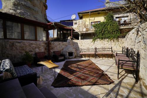 a patio with furniture and a stone wall at Glory Art Stone House in Goreme