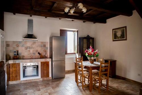 a kitchen with a table and a stainless steel refrigerator at Tower Cottage in Isola del Liri