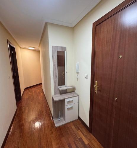 a hallway with a sink and a wooden door at Encanto del Norte in Villarcayo