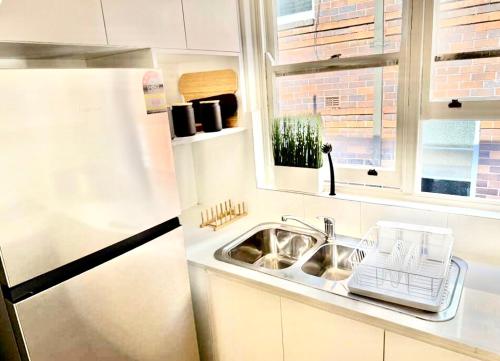 een keuken met een spoelbak en een koelkast bij Bondi Bungalow in Sydney