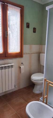 a bathroom with a toilet and a window and a sink at La Casetta Valdonica La Spezia in Calice al Cornoviglio
