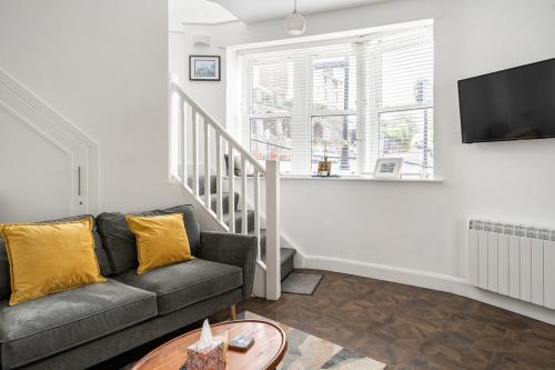a living room with a couch and a tv at 1 Cathedral Place - Cathedral Townhouses Cobh in Cobh