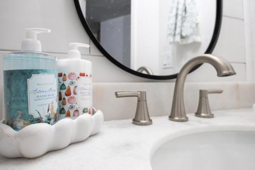 a bathroom sink with a bottle of soap and a mirror at Cozy One-Bedroom Coastal Retreat - Walk to Beach in El Granada