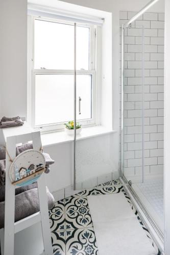 a bathroom with a shower and a rug on the floor at 1 Cathedral Place - Cathedral Townhouses Cobh in Cobh
