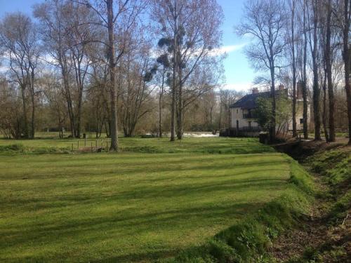 a field of grass with a house in the background at Moulin de la Chevriere in Saché