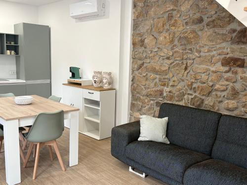 a living room with a couch and a stone wall at La Casa di Nonna Maria in SantʼAmbrogio