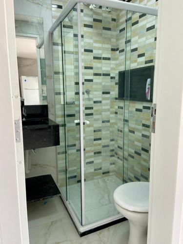 a bathroom with a glass shower with a toilet at Excelente Flat no alto de Bezerros in Bezerros