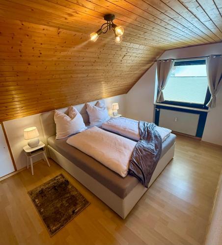 a large bed in a room with a wooden ceiling at Surki's Loggia an der Sonne in Schluchsee