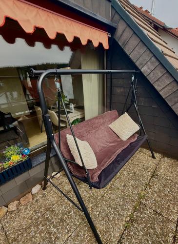 a porch swing sitting on the side of a house at Surki's Loggia an der Sonne in Schluchsee