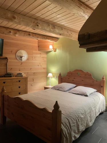 - une chambre avec un grand lit et un mur en bois dans l'établissement Le Chalet d'Elisabeth, à Saint-Véran