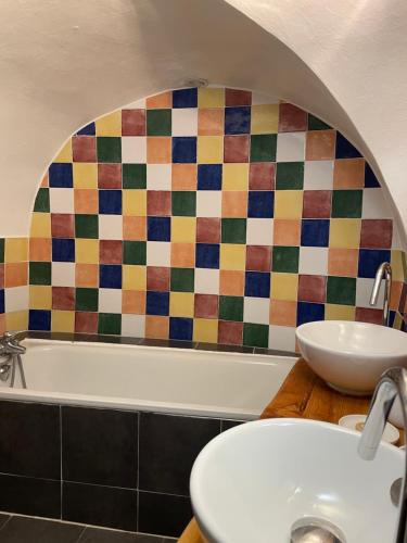 La salle de bains est pourvue d'un lavabo et d'un mur en carrelage coloré. dans l'établissement Le Chalet d'Elisabeth, à Saint-Véran
