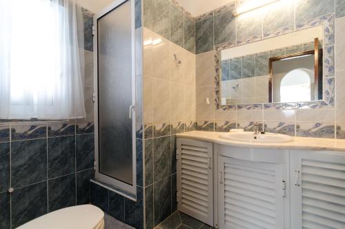 a bathroom with a shower and a toilet and a sink at Armação de Pêra Villa Hedwiges in Armação de Pêra