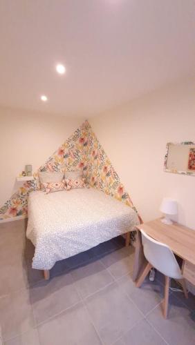 une chambre avec un lit, un bureau et une table dans l'établissement Charmant logement proche gare, à Villemomble