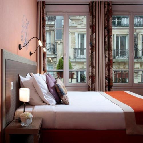 a bedroom with a large bed and a window at Hotel Residence Foch in Paris