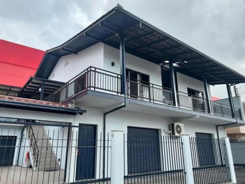 a white building with a balcony and a fence at Conforto em Local Privilegiado 2 in Itajaí