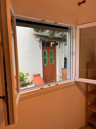 a window with a view of a house at Sufiko Studios - Drosia in Armenistis
