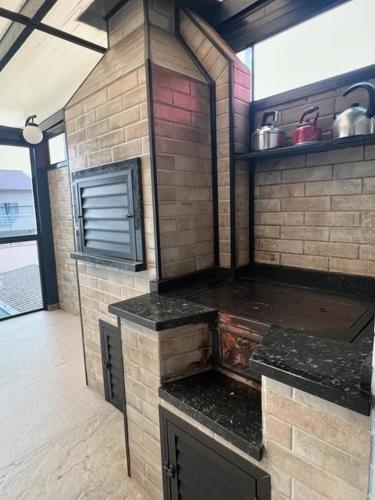 a kitchen with a brick wall and a stove at Conforto em Local Privilegiado 2 in Itajaí