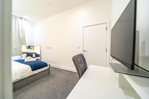 a bedroom with a bed and a flat screen tv at The Essex Apartments - Ashby House in Chelmsford
