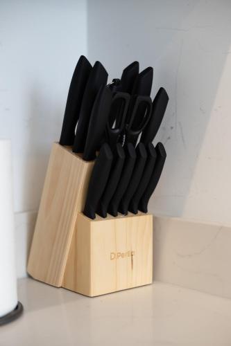 a wooden knife block filled with black knives at The Essex Apartments - Ashby House in Chelmsford