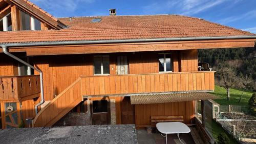a wooden house with a white chair in front of it at Time out near Lake of Thun & Emmental region in Fahrni