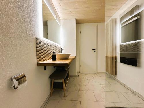 a bathroom with a counter and a sink on a wall at Time out near Lake of Thun & Emmental region in Fahrni