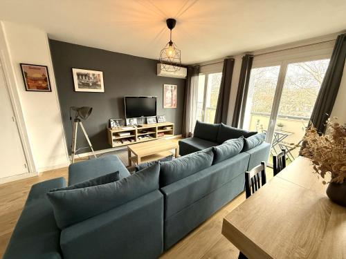 un salon avec un canapé bleu et une table dans l'établissement Le St Aubin appartement Hypercentre de Toulouse, à Toulouse