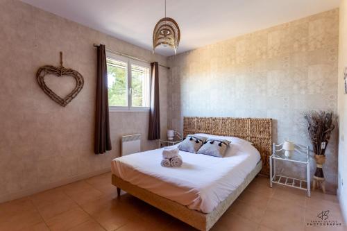 a bedroom with a bed and a heart wall at La Terrasse d'Azur - Vue sur la mer in Lapalme