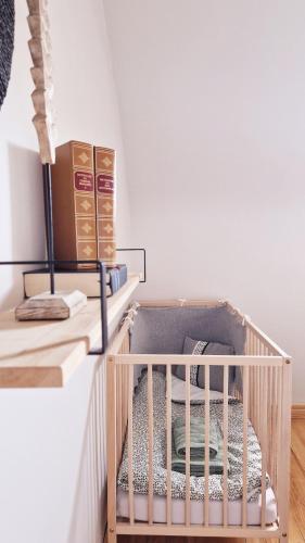 a crib in a room with a white wall at La Maison des Petits Bonheurs in Rixheim
