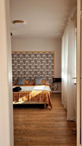 a bedroom with a bed and a wall at La Maison des Petits Bonheurs in Rixheim